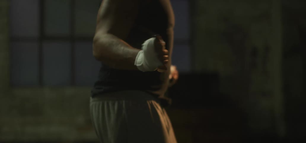 A man with taped hands jumps rope indoors