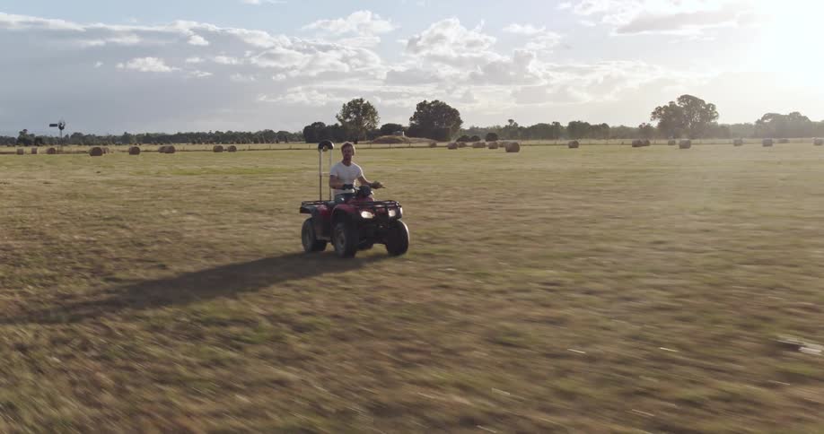 A man driving an atv on a farm