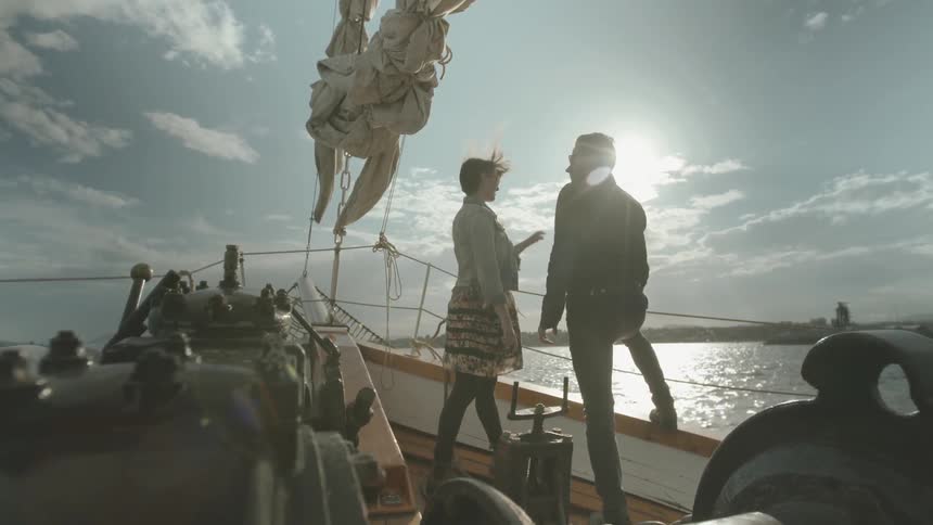 Two people are standing on the boat talking