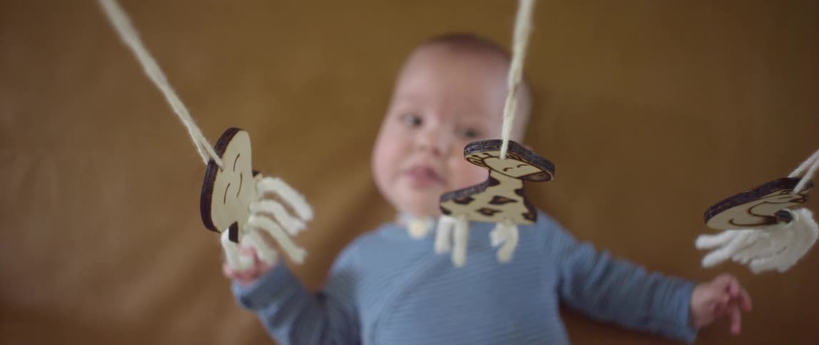Baby lying on her back looking at a mobile