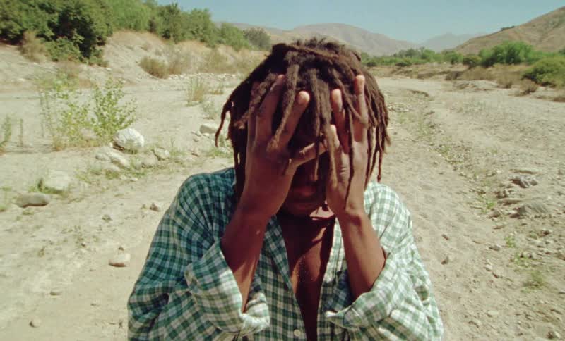 A man standing in an empty area and shaking his head