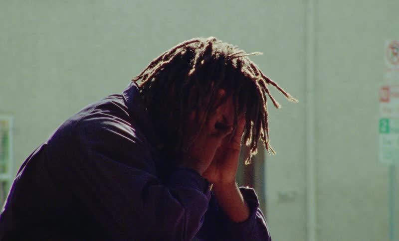 Black male with hands on face sad