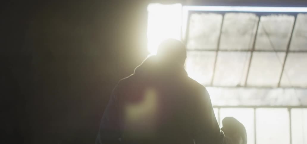 Silhouette of a boxer inside an abandoned warehouse at sunset