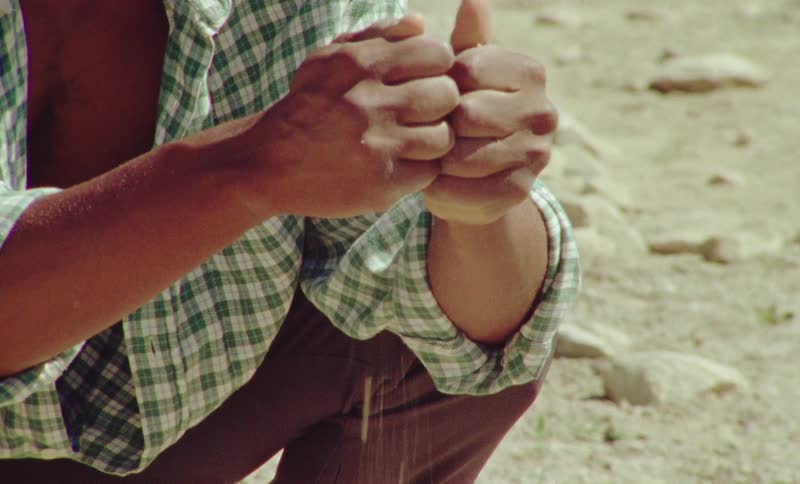 A man drops sand in the desert
