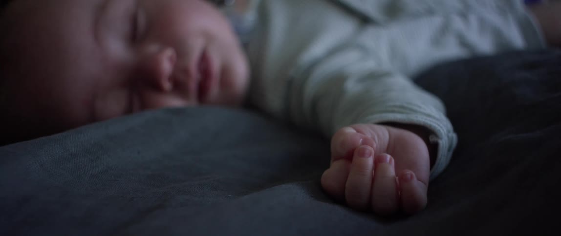A baby sleeping on a bed