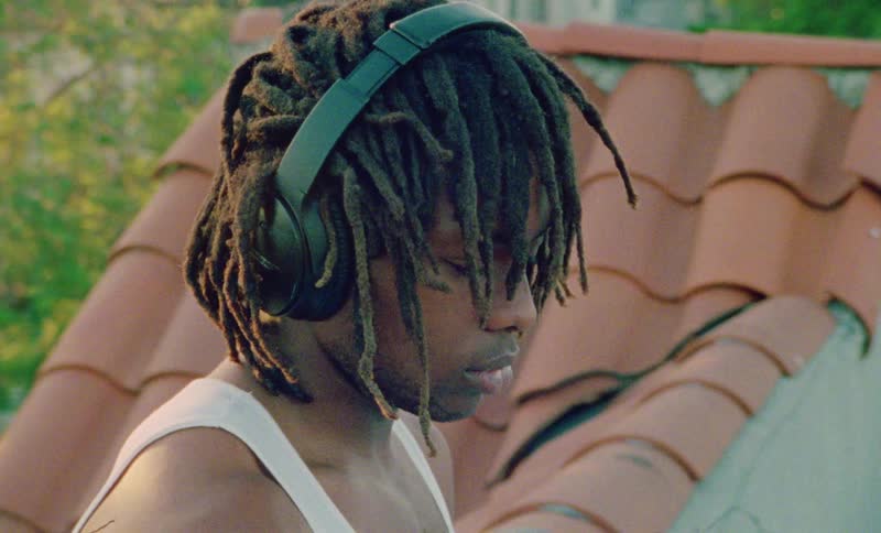 A young man listens to music on his headphones outside