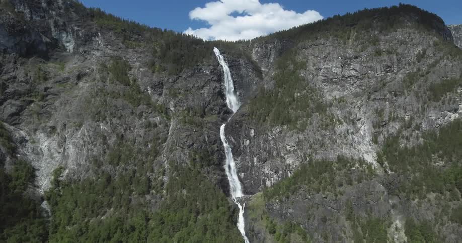 Tall waterfall flowing down a large mountain side