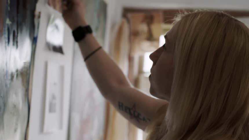 A woman is paining on paper