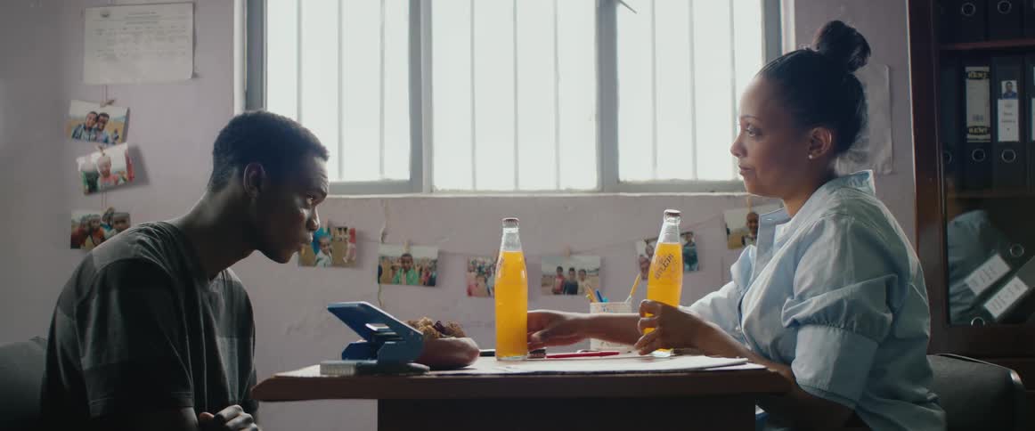 Teacher shares a soft drink with a student in her office at school