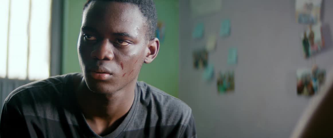 A man is sitting in a room during the day