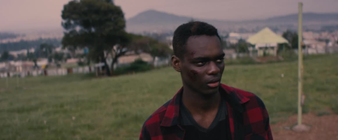 A man is walking outdoors at dusk