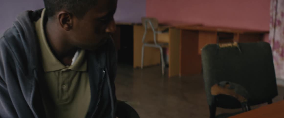 A boy sits at the desk in the classroom