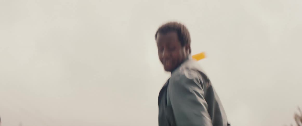 A man kicking a teenager on a street takes a soda bottle and hits him in the head with it