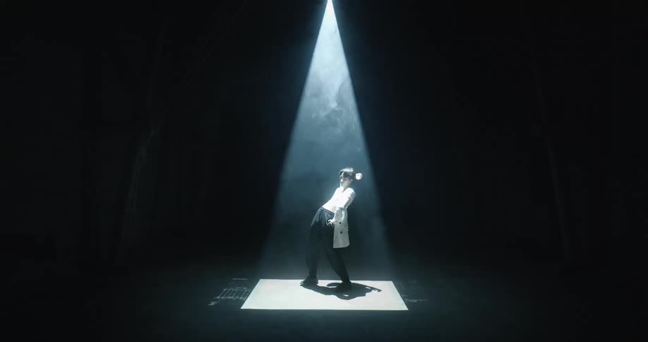 A model posing under a strobing spotlight