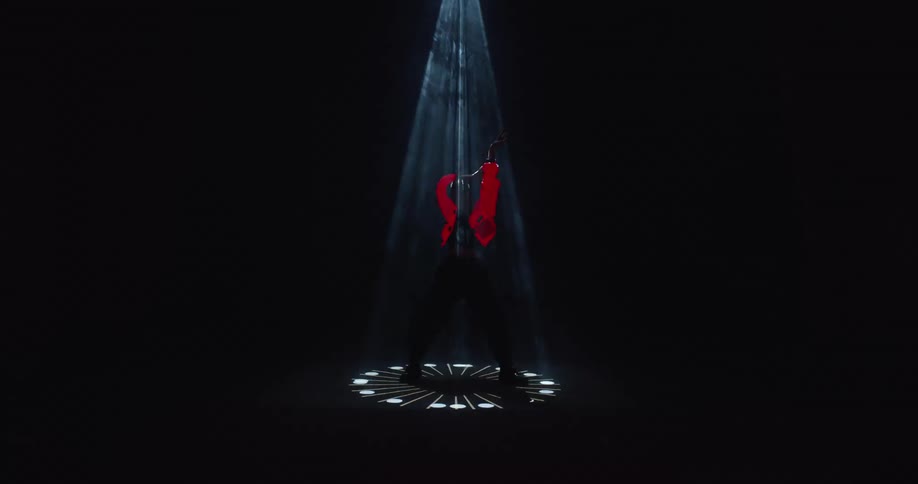 A static shot of a person standing in a spotlight