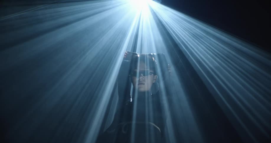 A woman standing under a bright spotlight