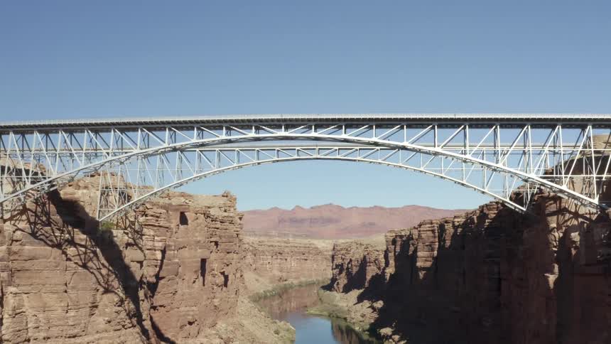 Two arched metal bridges over a canyon in the mountains