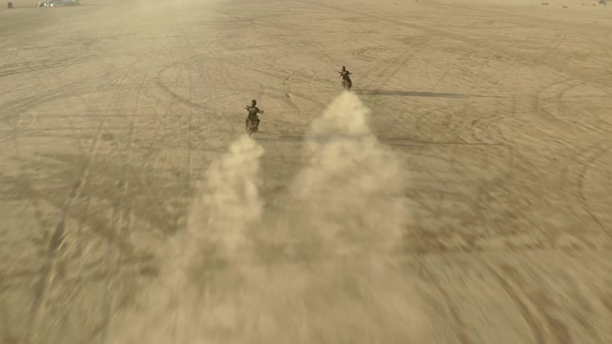 2 humans driving in the desert