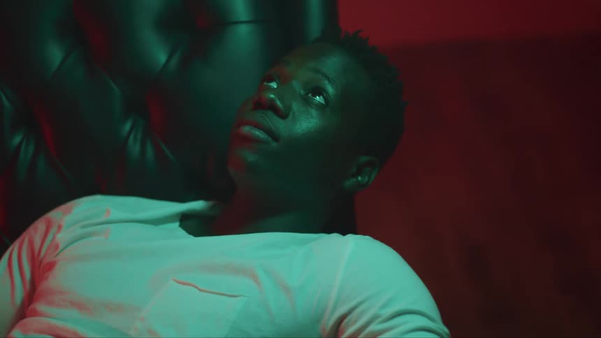 A man is sitting on a chair in his house