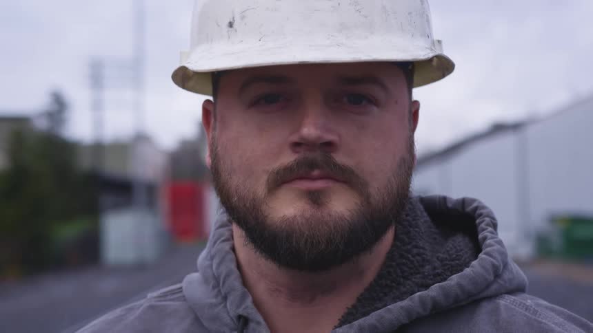 Construction supervisor wearing a white hard hat looking at the camera