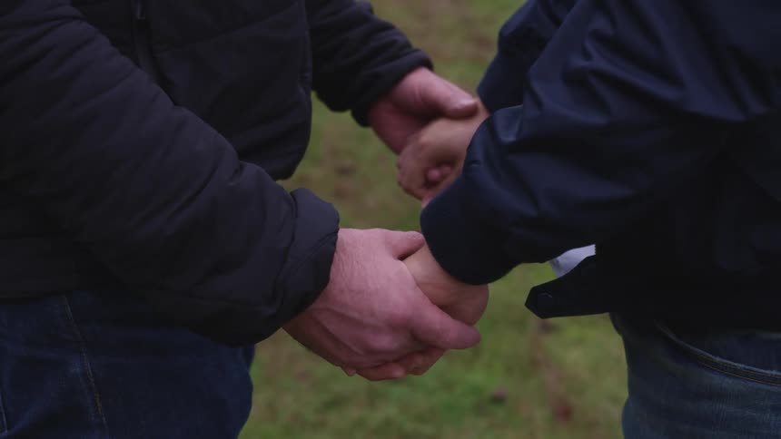Two men holding hands