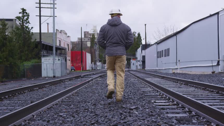 A man walking down train tracks
