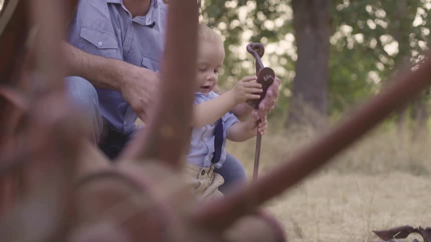 A child plays with a tool on the field