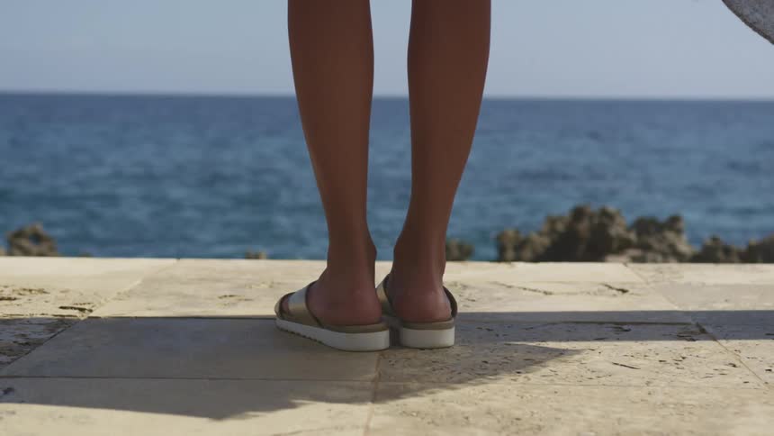 A close up of a womans feet at the beach