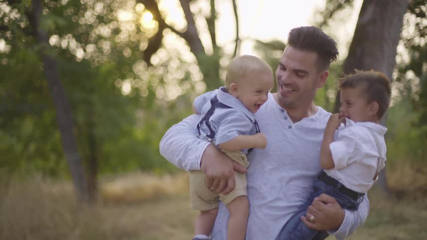 A father smiles while holding his children
