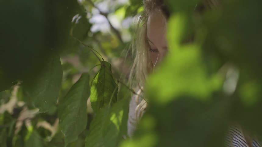 A girl is standing by a tree in spring
