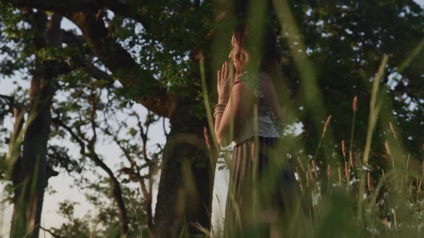A woman praying in a forest