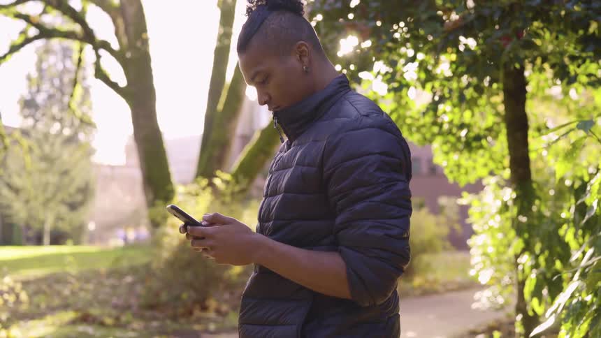 A man standing and looking at his phone