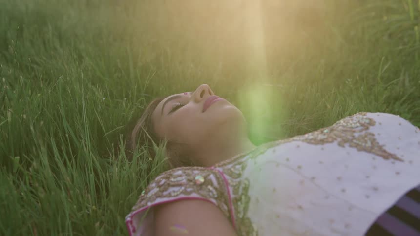 A woman is laying on the grass in spring