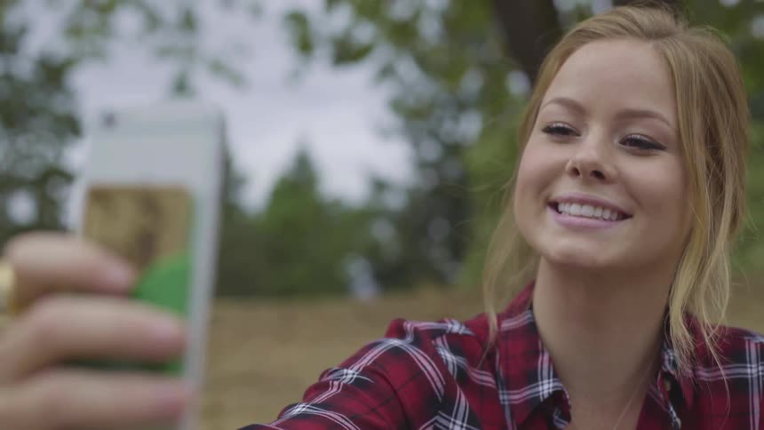 A teenage girl takes a selfie outside
