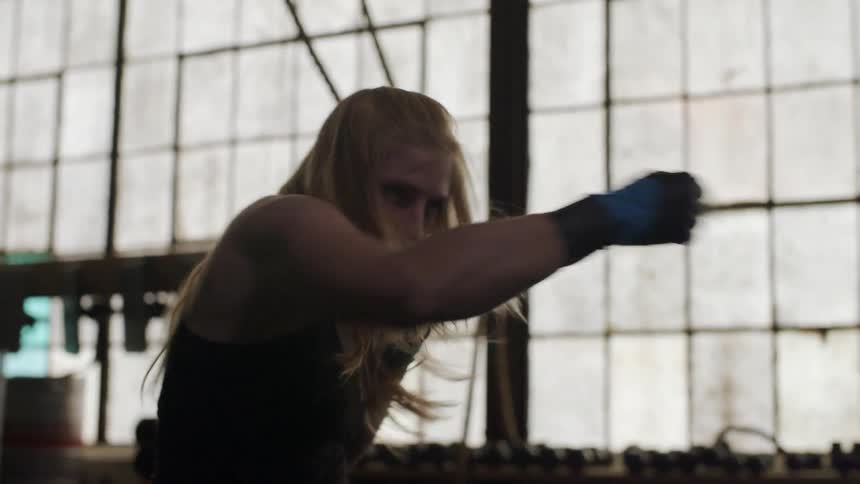 A woman spars and boxes in a gym