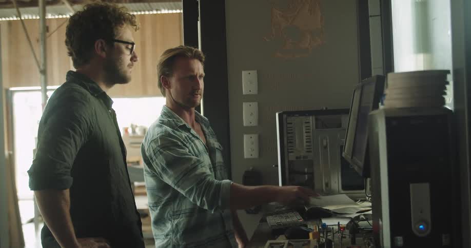 Two men in an office look at a computer