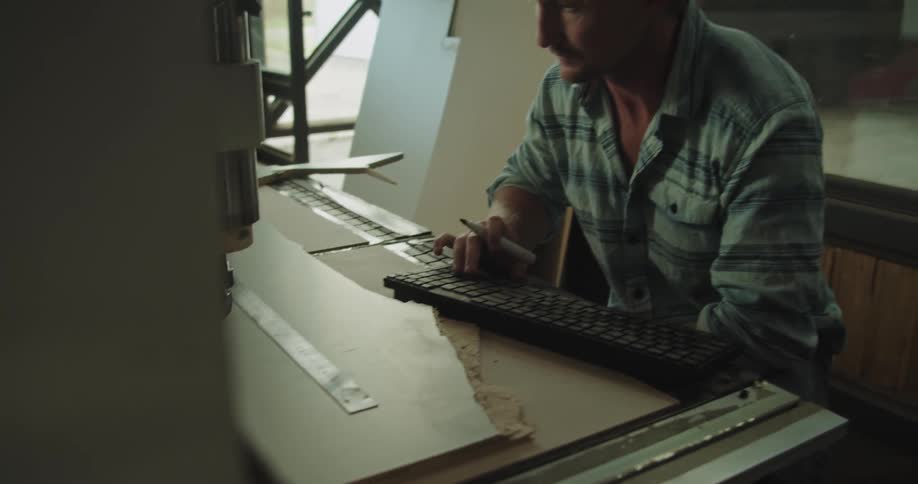 Man measuring and programming an autmatic drilling machine on a workshop