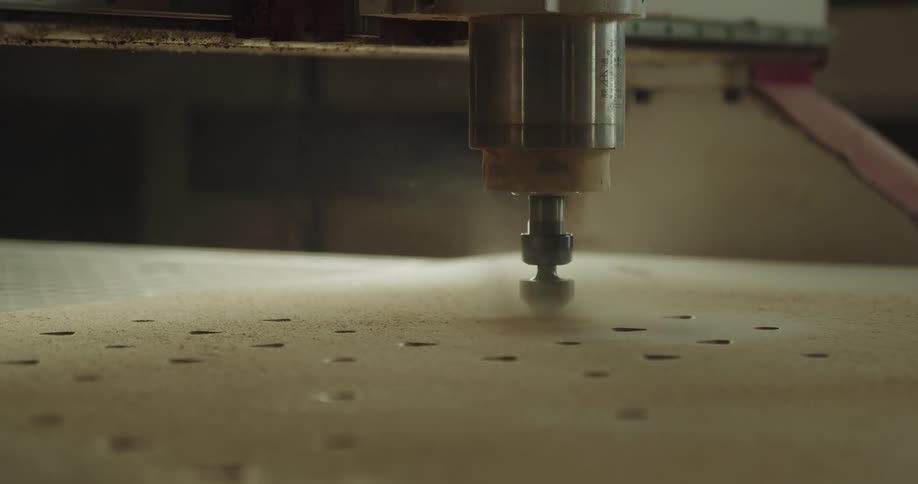 An electric drill drilling into wood with dust
