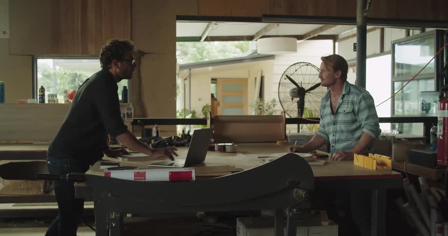 Two men are working on a project together in a workshop