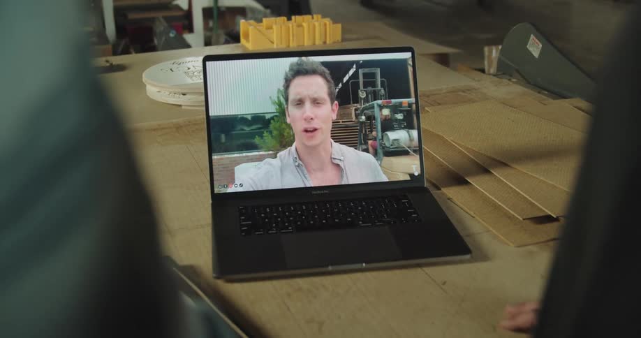 Two coworkers video chat with another worker on a construction site