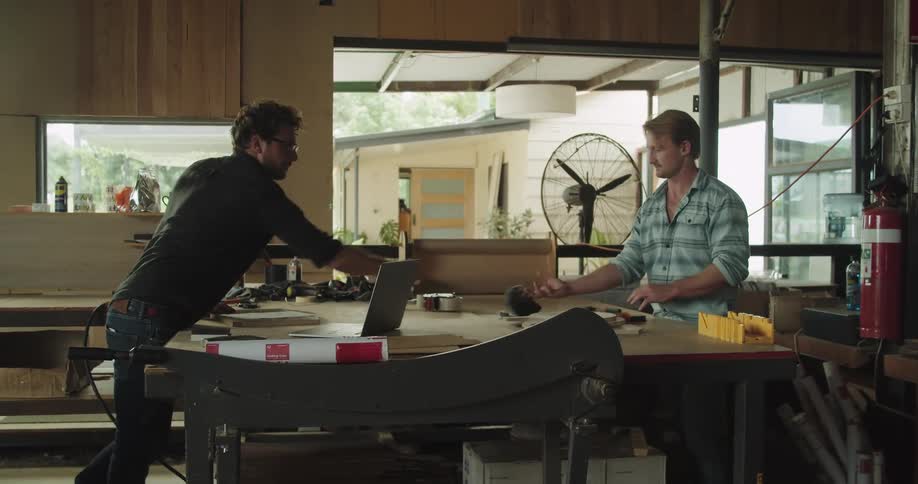 Two men talk and work together