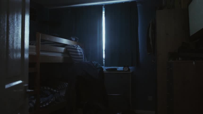 Children's' room with curtains closed and messy bunk beds