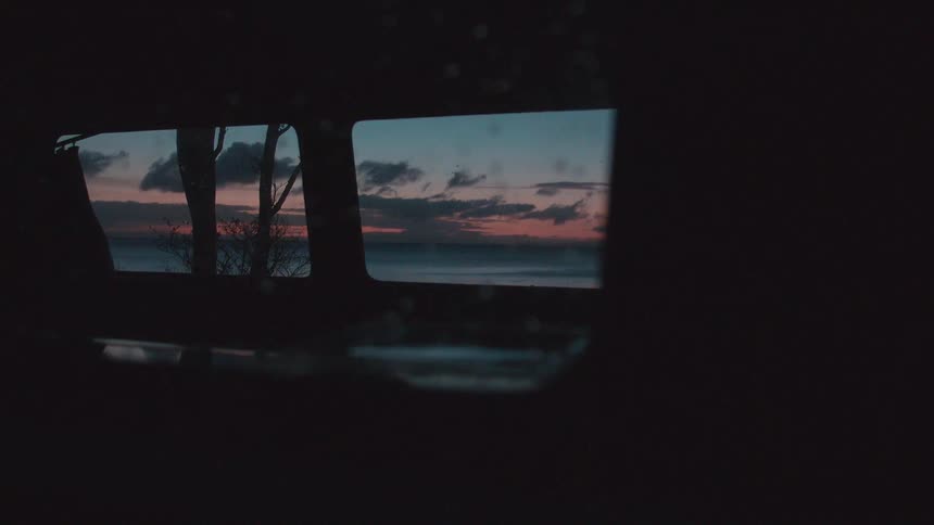 A beach sunset through a car window