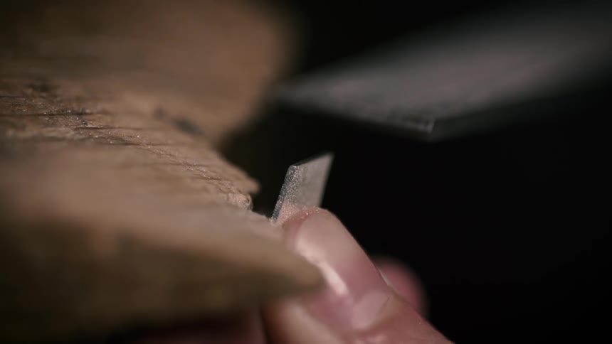 A person uses a file to smooth metal and wood