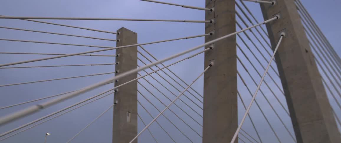 Cars are driving over a bridge at dusk