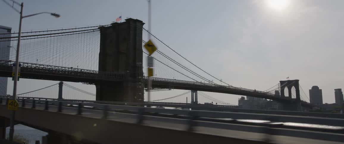 Bridge over a river with streets and overpass bridges with a skyline with sunny sky