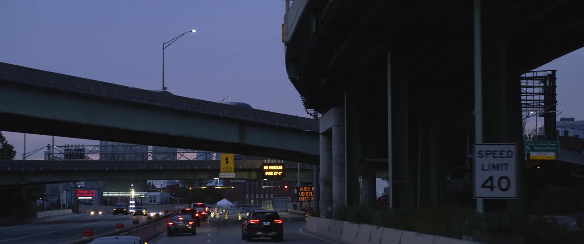 Highway with traffic vehicles and overpass bridges at dawn
