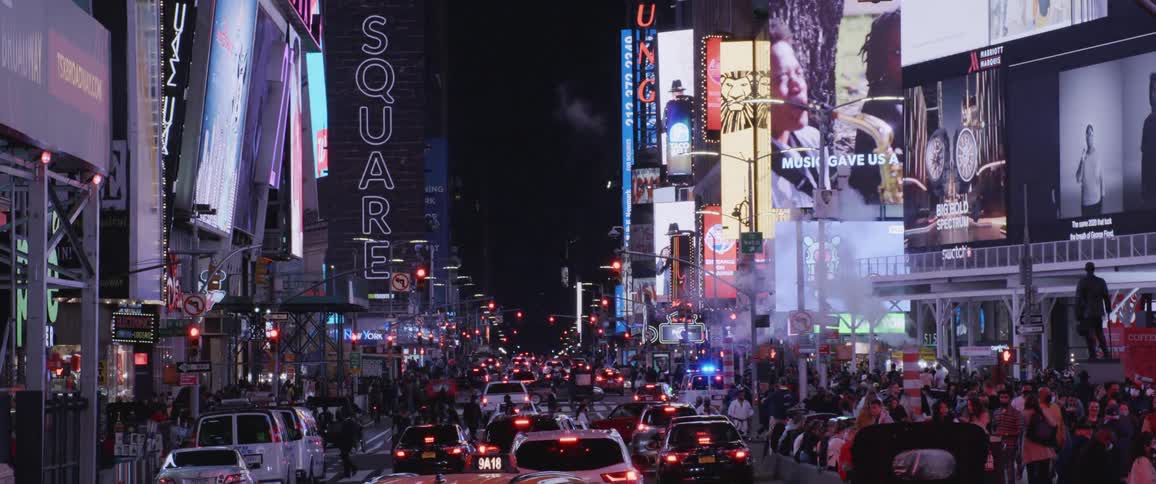 Vehicles in the heavy traffic of a street through the city downtown at night