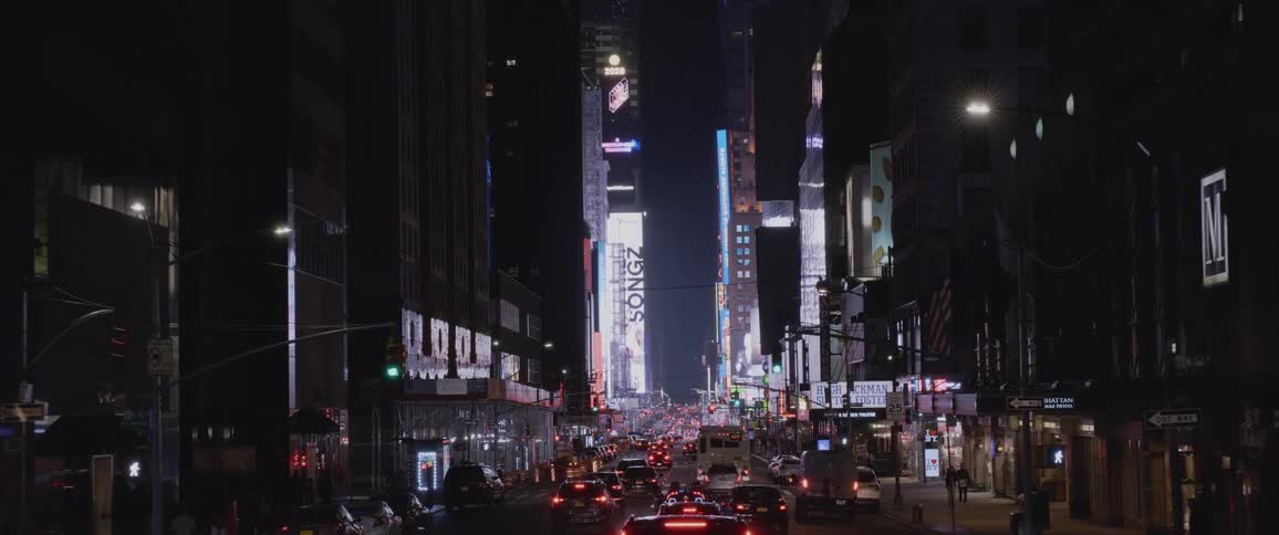Downtown area with a street filled with traffic and surrounded by illuminated buildings