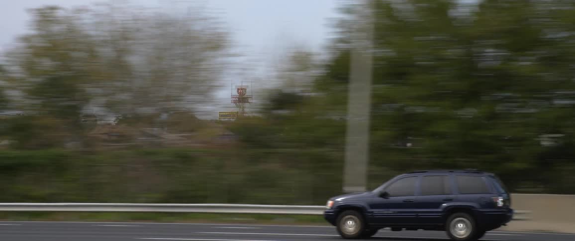 Driving on a freeway passing an airport and other vehicles in the daytime